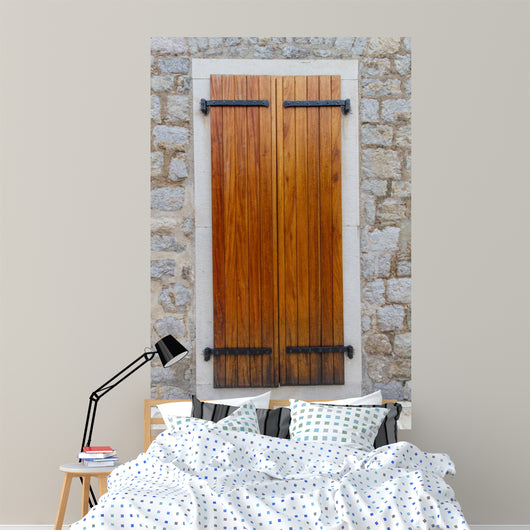 Large wooden shutters in a stone wall 