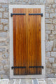 Large wooden shutters in a stone wall 