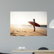 Beautiful surfer girl in the beach with her surfboard at sunset Wall Mural