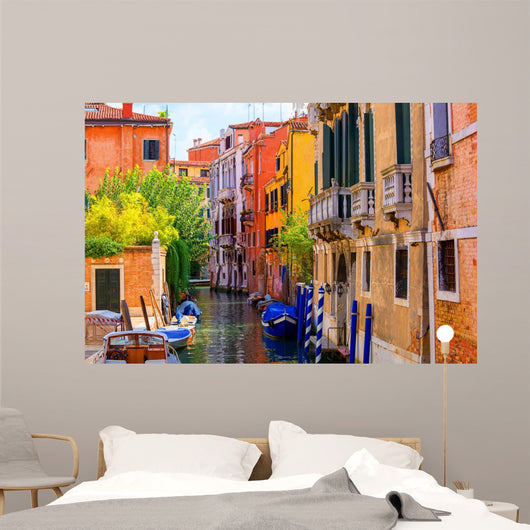 multicolored houses astride one of Venetian canals. 