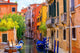 multicolored houses astride one of Venetian canals. 