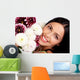 Smiling woman with flowers. Close up. Wall Mural