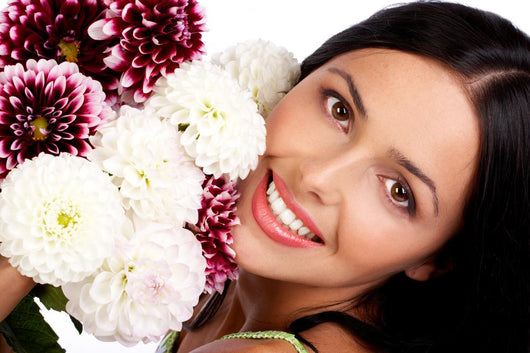 Smiling woman with flowers. Close up. Wall Mural