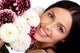 Smiling woman with flowers. Close up. Wall Mural