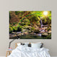 beautiful waterfall comes out of a huge rock in the forest Wall Mural