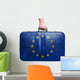 Tourist hand holding vintage leather travel bag with flag of Eur 
