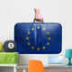 Tourist hand holding vintage leather travel bag with flag of Eur 