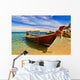 Longtail boat in tranquil bay Wall Mural