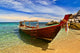 Longtail boat in tranquil bay Wall Mural
