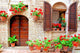Italian house front with colorful potted flowers Wall Mural