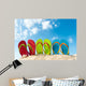 Row of colorful flip flops on beach against sunny sky 