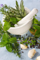 Mortar and pestle with fresh herbs, garlic and peppercorns. Wall Mural
