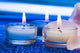 Candles with flower on blue background 