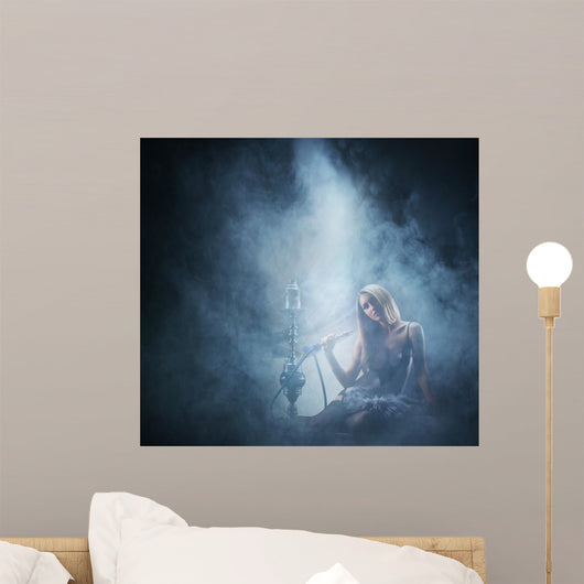 Beautiful lady smoking the hookah on a smoky background Wall Mural