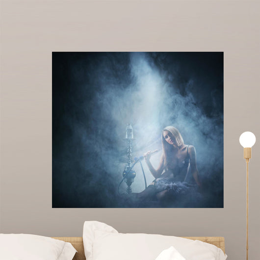 Beautiful lady smoking the hookah on a smoky background Wall Mural