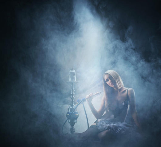 Beautiful lady smoking the hookah on a smoky background Wall Mural