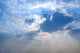 Sun Rays from under Cloud Covering the Sun Blue Sky Background Wall Mural