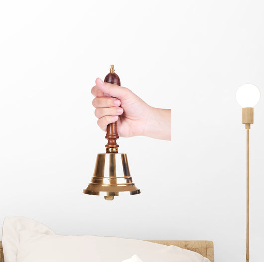 Gold retro school bell in hand isolated on white Wall Decal