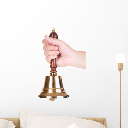 Gold retro school bell in hand isolated on white Wall Decal