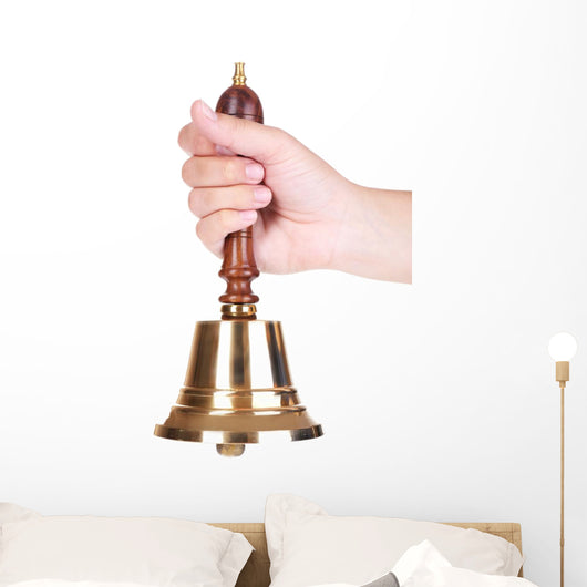 Gold retro school bell in hand isolated on white Wall Decal