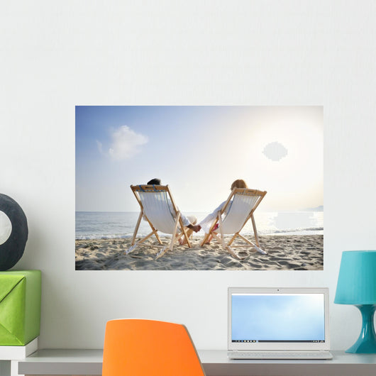 romantic couple on deckchair relaxing on the beach Wall Mural