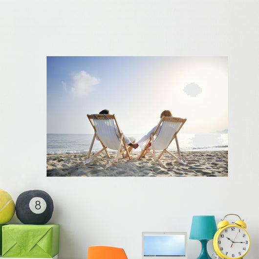 romantic couple on deckchair relaxing on the beach Wall Mural
