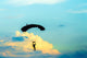 unidentified skydiver, parachutist on blue sky Wall Mural