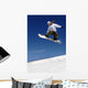Woman Snowboarder in Flight With Sky Behind Wall Mural