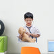 Young Asian doctor boy playing and curing bear toy isolated on w Wall Decal
