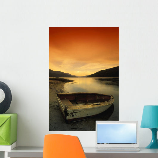 Old Rowboat At Water's Edge With Sunset Background Wall Mural