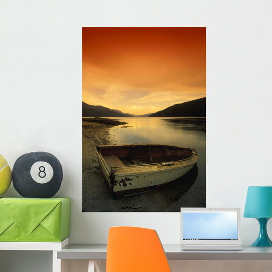 Old Rowboat At Water's Edge With Sunset Background Wall Mural