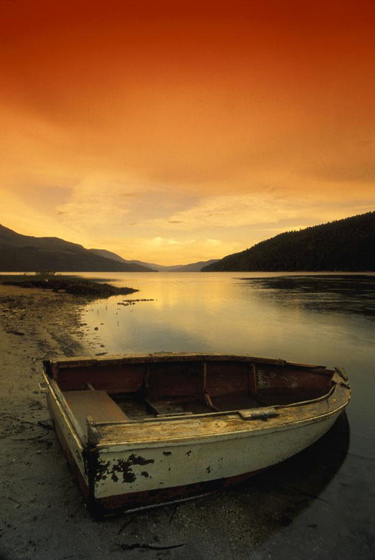 Old Rowboat At Water's Edge With Sunset Background Wall Mural