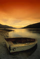 Old Rowboat At Water's Edge With Sunset Background Wall Mural