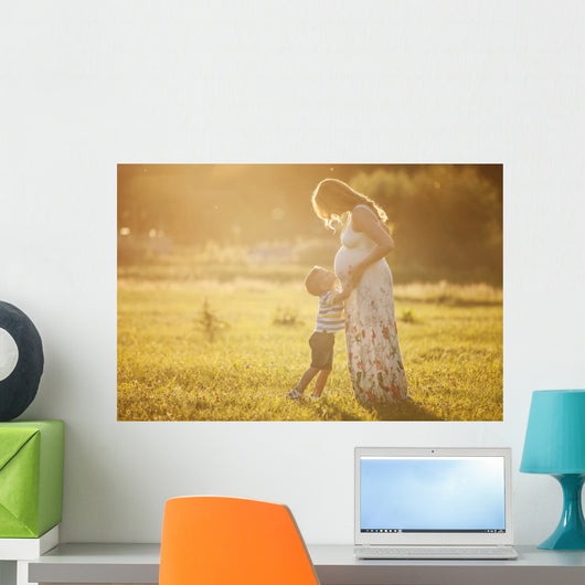 Small boy kissing belly of his pregnant mother outdoors Wall Mural