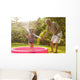 Grandparent and grandkid playing with hose Wall Mural