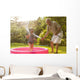 Grandparent and grandkid playing with hose Wall Mural