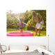 Grandparent and grandkid playing with hose Wall Mural