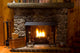 close-up of stone fireplace in log cabin with blazing fire Wall Mural