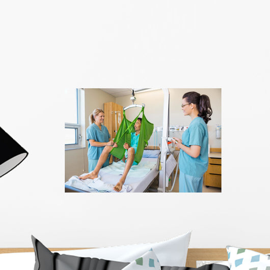Nurses Looking At Patient Sitting On Cloth Of Hydraulic Lift Wall Mural