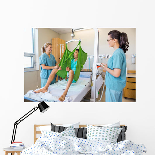 Nurses Looking At Patient Sitting On Cloth Of Hydraulic Lift Wall Mural