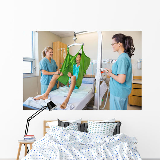 Nurses Looking At Patient Sitting On Cloth Of Hydraulic Lift Wall Mural