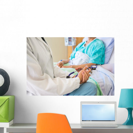 Female Doctor Sitting With Patient On Hospital Bed Wall Mural