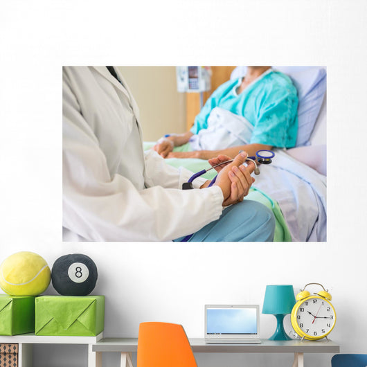 Female Doctor Sitting With Patient On Hospital Bed Wall Mural