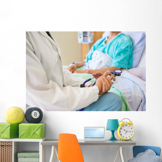 Female Doctor Sitting With Patient On Hospital Bed Wall Mural