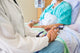 Female Doctor Sitting With Patient On Hospital Bed Wall Decal