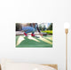 Young woman plays adventure/mini golf in summer evening Wall Mural