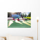 Young woman plays adventure/mini golf in summer evening Wall Mural