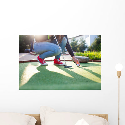 Young Woman Plays Adventure/Mini Golf In Summer Evening Wall Decal shown on a wall