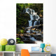 beautiful waterfall comes out of a huge rock in the forest Wall Mural
