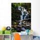 beautiful waterfall comes out of a huge rock in the forest Wall Mural